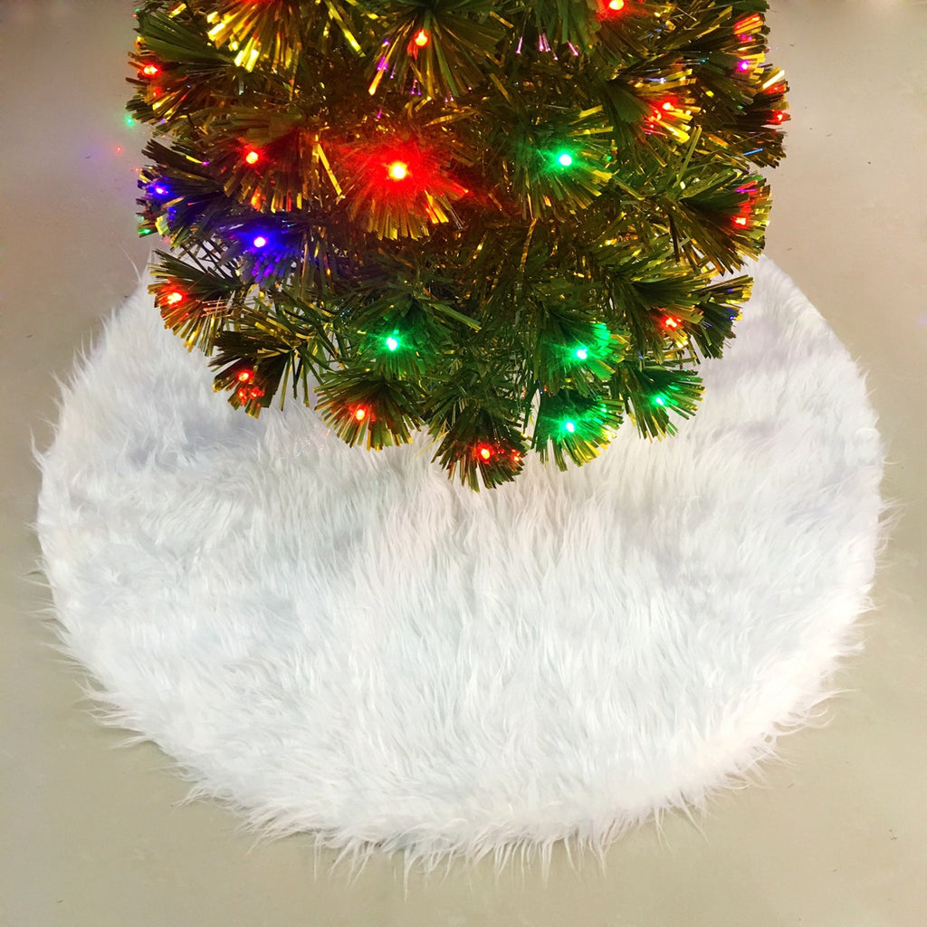 White plush tree skirt under a lit Christmas tree