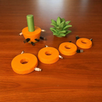 Orange cable slices in different sizes, each holding one wound cable, beside the pineapple base and leaf top